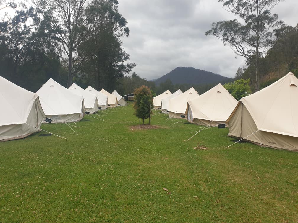 two rows of white canvas bell tents facing each other