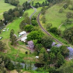 An aerial view of a lush green countryside property featuring a winding river